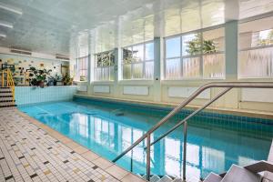 a large swimming pool with blue water and windows at Ferienappartement in Black Forest in Baiersbronn