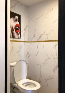 a bathroom with a toilet with a picture of a woman with lipstick at Pas Sages in Le Tréport +9 photos