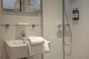 a white bathroom with a sink and a shower at Hotel 't Paviljoen in Rhenen +111 photos