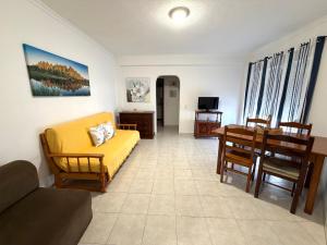 a living room with a yellow couch and a table at Edificio Nau B in Armação de Pêra