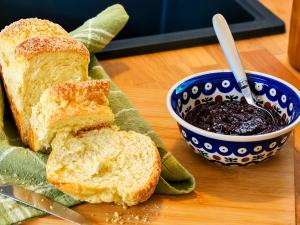 a cutting board with a sandwich and a bowl of bread at Tiny House Zajączki nad Narwią in Zajączki
