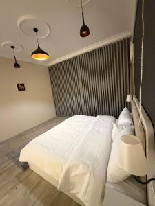 a bedroom with a white bed with a metal headboard at أوبال ستاي المطار in Abha