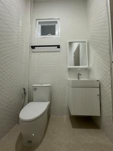 a white bathroom with a toilet and a sink at The Summer Cozy Cottage in Haad Chao Phao +24 photos