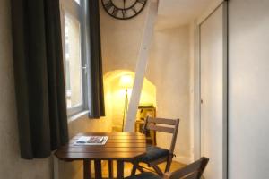 a table and a chair in a room with a clock at Gîte du Vieux Lyon in Lyon