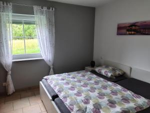 a bedroom with a bed and a window at Ferienwohnung Wagner mit Terrasse und Kinderspielplatz in Küps +20 photos