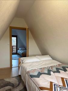 a bedroom with a bed in a attic at ZELENI BOR koliba vikendica Pale in Pale +9 photos