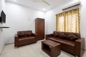 a living room with a couch and a chair at Hotel Aditya Premier in Guntūr