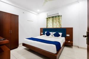 a bedroom with a large bed with blue and white sheets at Hotel Aditya Premier in Guntūr
