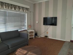 a living room with a couch and a flat screen tv at Kapokbos in Sutherland
