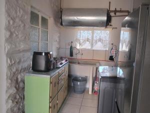 a small kitchen with a sink and a refrigerator at Kapokbos in Sutherland