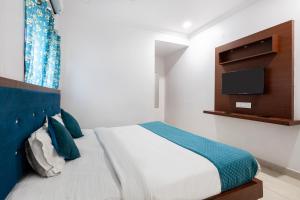 a bedroom with a bed with a tv on the wall at Hotel Aditya Premier in Guntūr