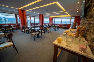 a dining room with tables and chairs and windows at MIL810 Ushuaia Hotel in Ushuaia