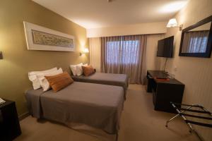 a hotel room with two beds and a window at MIL810 Ushuaia Hotel in Ushuaia +35 photos