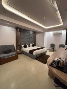 a bedroom with a bed and a couch and a table at Jayati Palace Hotel in Rudraprayāg