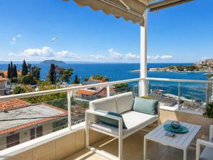 a balcony with a white chair and a view of the ocean at MK Seaview Stays in Neos Marmaras