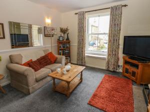a living room with a couch and a television at Kernot Cottage in Richmond