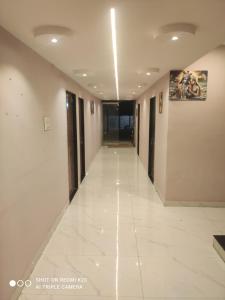 a hallway of a building with a white tile floor at Sahyadri Lodge Yermala in Yermala