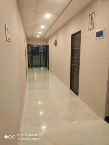 a hallway of a building with a door and a tile floor at Sahyadri Lodge Yermala in Yermala