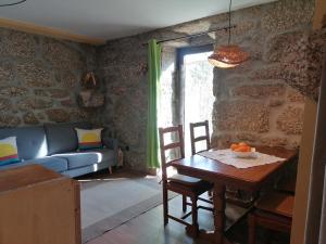 a living room with a table and a couch at Country House - Hippie Garden in Vieira do Minho