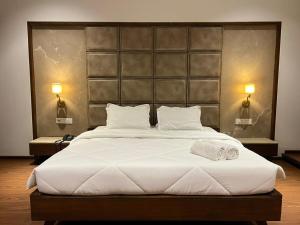 a bedroom with a large bed with two towels on it at DK Club & Resort in Bārdoli