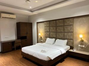 a bedroom with a large bed and a desk at DK Club & Resort in Bārdoli