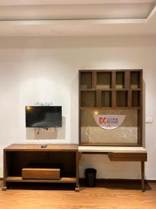 a wooden entertainment center with a tv on a wall at DK Club & Resort in Bārdoli