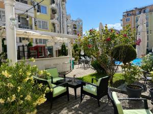 a patio with chairs and tables and plants at Vanilla Garden Apartments in Sunny Beach