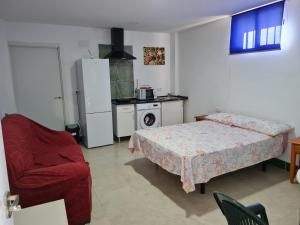 a bedroom with a bed and a chair and a refrigerator at PUESTA DE SOL-Matalascañas in Matalascañas