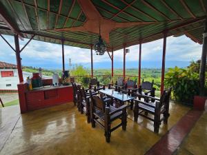 a patio with a table and chairs and a kitchen at Finca Hotel Caracolí I A 15 Minutos del Parque del Café in Montenegro