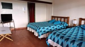 a hotel room with two beds and a television at Finca Hotel Caracolí I A 15 Minutos del Parque del Café in Montenegro +31 photos
