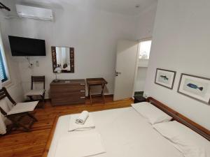 a bedroom with a bed and a desk and a television at Yiayia's guesthouse in Skopelos Town