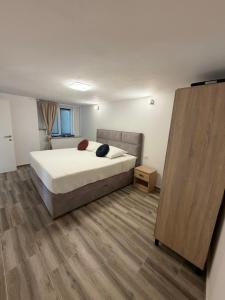 a bedroom with a bed and a wooden floor at Apartmani Brač in Pučišća