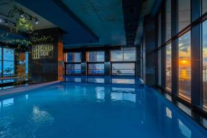 a large swimming pool in a building with windows at Green Side Apart Hotel Official in Batumi +54 photos
