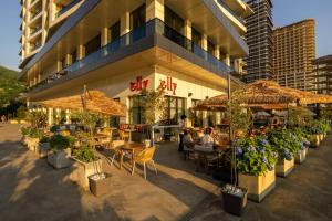 a restaurant with tables and umbrellas in front of a building at Green Side Apart Hotel Official in Batumi