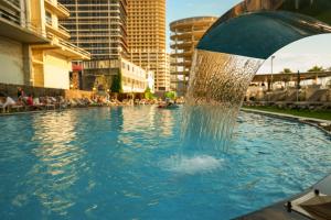 a fountain in the middle of a swimming pool at Green Side Apart Hotel Official in Batumi