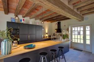 a kitchen with wooden ceilings and a counter with stools at Cloffy et son Domaine in Nouans-les-Fontaines