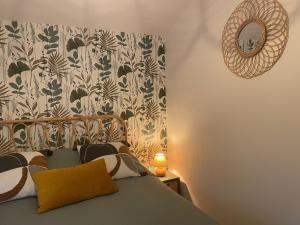 a bedroom with a bed with a mirror on the wall at L'étoile des pins in Longeville-sur-Mer