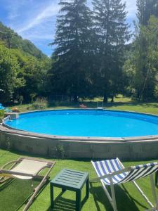 a large swimming pool with two chairs and a table at Le Château de Sorgues in Cornus