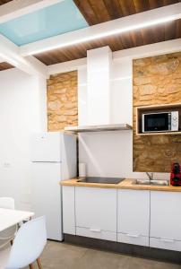 a kitchen with white cabinets and a microwave at A Calexa Sarria nº4 in Sarria