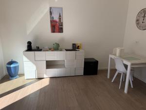 a living room with a white cabinet and a table at Artexia residence DIAMANTE A1 in Valenza +3 photos