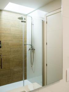 a shower with a glass door in a bathroom at A Calexa Sarria nº4 in Sarria