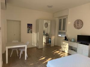 a living room with a table and a clock on the wall at Artexia residence DIAMANTE A1 in Valenza