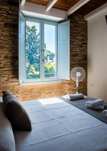 a bedroom with a large bed with a window at A Calexa Sarria nº4 in Sarria