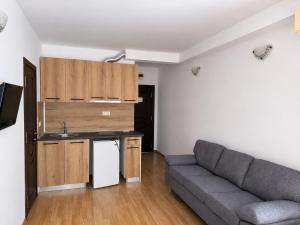 a living room with a couch and a kitchen at Vanilla Garden Apartments in Sunny Beach