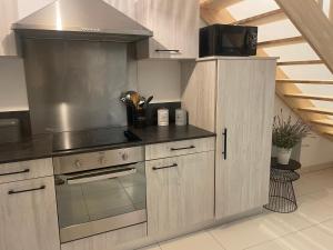 a kitchen with wooden cabinets and a stove top oven at L'étoile des pins in Longeville-sur-Mer