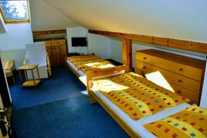 a bedroom with two beds and a dresser at Ubytovanie Zencuch in Drienica