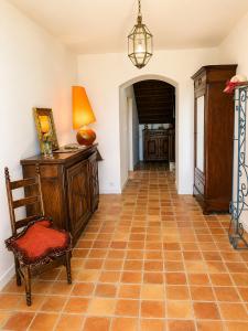 a hallway with a chair and a table and a lamp at Chambre double alcôve in Lagor