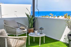 a patio with a chair and a table on a balcony at Coast Suites in Alcalá