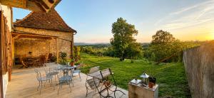 a patio with chairs and tables and a view of a yard at Chambre double alcôve in Lagor