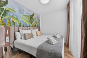 a bedroom with a bed and a wall with plants at Coast Suites in Alcalá